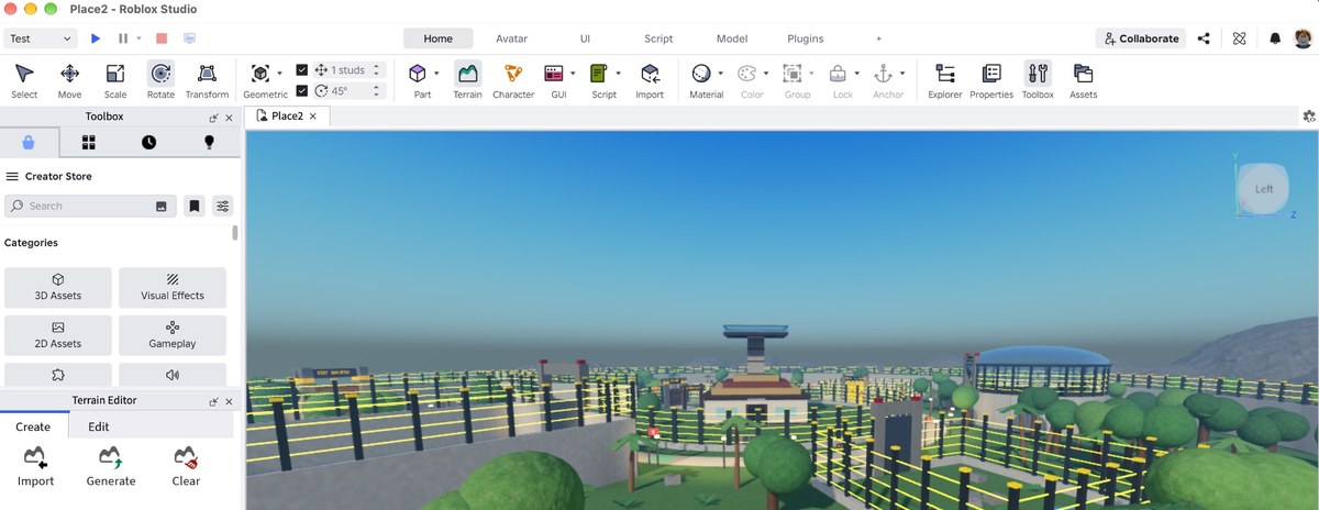 Roblox Studio on a Mac with a fenced map of buildings, trees and a domed arena in the 3D viewport, and the Toolbox and Terrain Editor panels on the left
