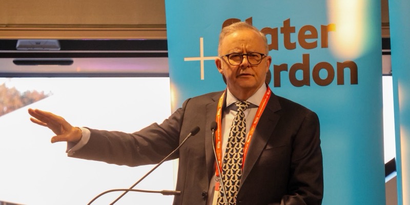 Anthony Albanese speaking at a podium with his arm outstretched