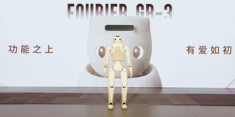 A cream-coloured Fourier GR-3 humanoid robot standing on a stage in front of a large screen showing the words Fourier GR-3 and Chinese text.