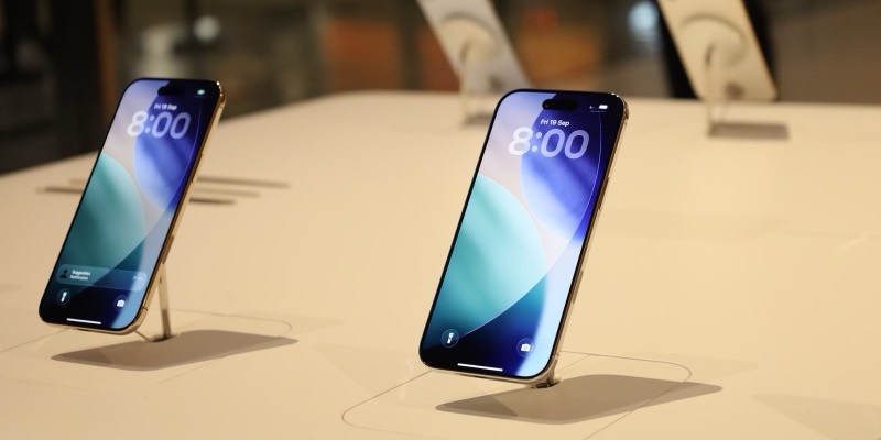 Two iPhones standing on display stands on a white table in an Apple Store, their lock screens showing 8:00 and Fri 19 Sep