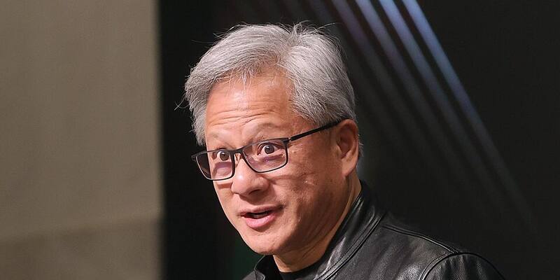 Jensen Huang, with grey hair and dark-rimmed glasses, wearing a black leather jacket and speaking