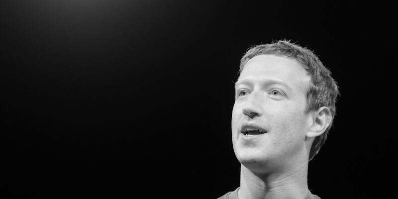 Black and white photo of Mark Zuckerberg speaking against a dark background
