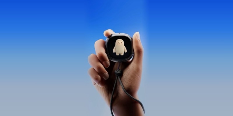 A hand holding the small, round Muse Charm device by its cord, showing a cute cream-colored character on its screen