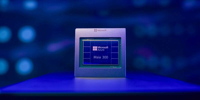 A square silver Microsoft chip package marked Microsoft Azure Maia 300, standing upright on a table under blue lighting.