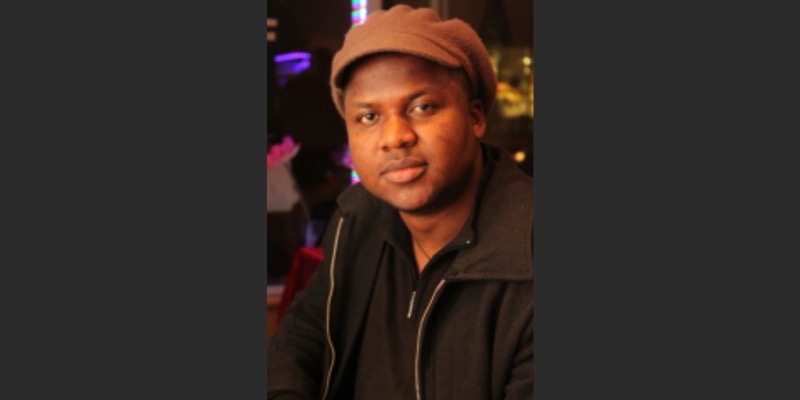 Thélyson Orélien wearing a brown flat cap and dark jacket