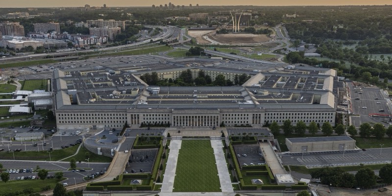Aerial view of the Pentagon building at dusk, with its central courtyard, parking lots and highways around it