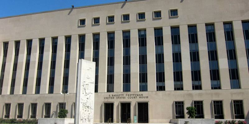 The pale stone facade of the E. Barrett Prettyman United States Court House in Washington DC under a blue sky