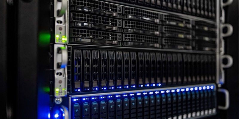 Close-up of black server racks with rows of drive bays and glowing blue and green status lights