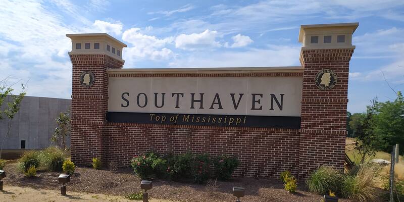 Brick and stone welcome sign reading Southaven, Top of Mississippi, under a blue sky