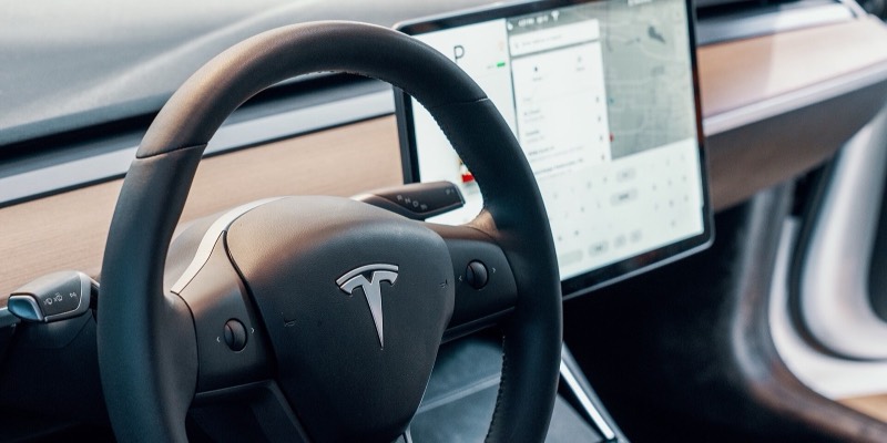 A Tesla steering wheel in front of the car’s large centre touchscreen