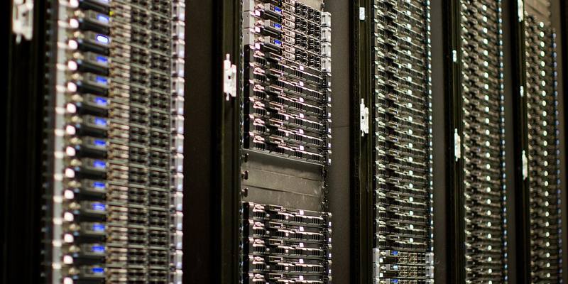 Rows of black server racks filled with Wikimedia Foundation servers, with small blue lights on the front panels.